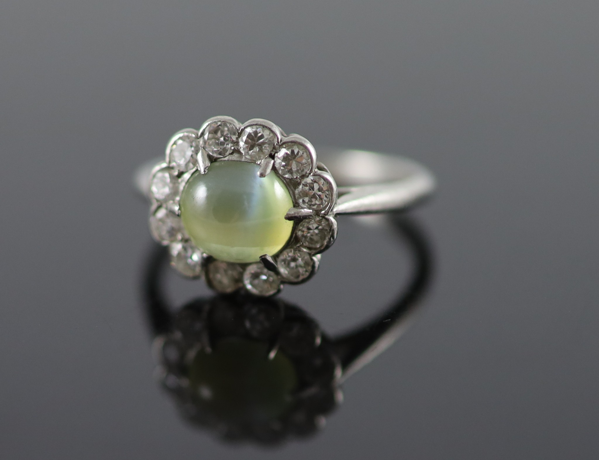 A 1920's/1930's platinum, cats eye chrysoberyl and diamond set oval cluster ring